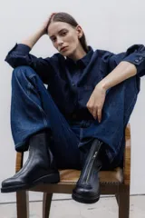 Bota corta de cuero color chocolate, con cierre central y suela de goma.