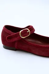 Ballerina marrón de gamuza con punta redondeada, cierre con pulsera y hebilla metálica dorada ajustable.