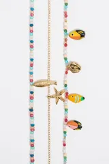 Collar corto de tres hilos: uno de cuentas de colores, otro de strass y otro de cadena dorada con dijes de animales marinos y aves tropicales.