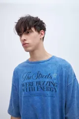 Remera celeste con efecto marmolado y estampa en el pecho, de corte boxy y mangas cortas.