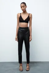 Leggings de tiro alto color negro con efecto cuero y cierre lateral oculto en el bajo.