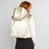 Campera plastrón con capucha color beige metalizado, con cierre frontal parcial y cordones ajustables.