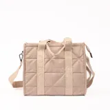 Bolso tipo shopper color beige con diseño acolchado en forma de rombos. Tiene doble asa corta y correa larga extraíble con letras bordadas.