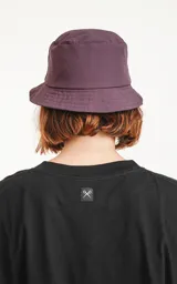 Gorro tipo piluso color morado con logo de tijeras en etiqueta negra.