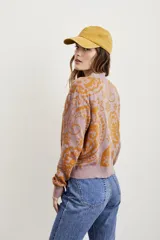 Cárdigan color lila con estampado jacquard en color ocre, con cuello en V, calce al cuerpo y cierre frontal con botones.