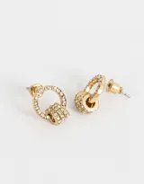 Aros pasantes dorados con forma circular y tres dijes colgantes, con incrustaciones de strass.