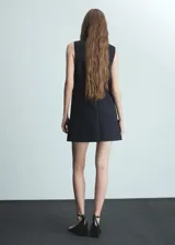 Vestido corto azul marino sin mangas, con cuello redondo, corte recto, botones decorativos en la parte inferior y cierre trasero invisible.
