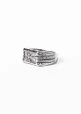 Anillo signet rectangular de acero quirúrgico pulido, con cruz estilizada en alto relieve y grabados geométricos en los laterales.