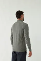 Campera tejida azul marino con cuello alto, cierre frontal y puños acanalados con detalle de línea roja.