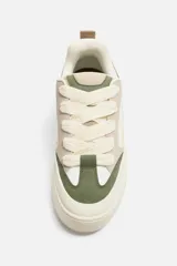 Zapatillas deportivas blancas de estilo skate con cordones gruesos y suela con plataforma.