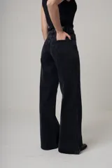 Jean de denim negro con corte wide leg y tiro alto.