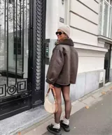 Campera marrón de cuero con cuello de piel sintética y cierre con botones.