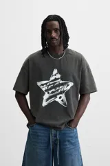 Camiseta negra con efecto lavado, cuello redondo, manga corta y estampado de estrella con texto en el centro.
