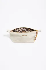 Neceser mediano de nylon color crudo, con estructura blanda, cierre de cremallera, tirador de cordón, logo metálico y acabados dorados.