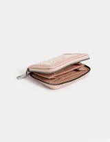 Billetera de cuerina color blanco crudo con cierre circundante y moño en relieve.