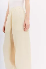 Pantalón babucha color marrón de lino, con cintura elastizada, bolsillos laterales y largo al tobillo.