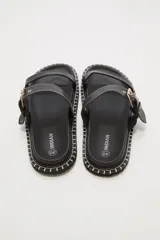 Sandalias negras de cuero sintético con doble tira y hebilla dorada ajustable.