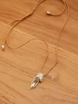 Collar con dije de medusa dorada y cordón ajustable color beige.