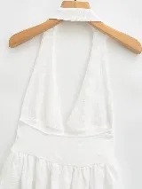 Top blanco con escote halter, espalda descubierta y volado en el ruedo.