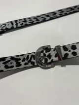 Cinturón con estampado animal print en blanco y negro, con hebilla metálica plateada.