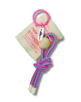 Llavero con aro rosado, etiqueta de tela color crema con texto y logo, cuenta de madera clara y cordón trenzado a rayas turquesa y fucsia.