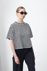 Remera de manga corta con cuello a la base, confeccionada en tejido de rayas horizontales blancas y negras, con silueta relajada.