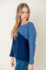 Sweater de lana color beige y azul, con corte diagonal en el pecho.