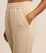 Pantalón deportivo color morado, de algodón y poliéster, con cintura elástica y bolsillos laterales.