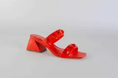 Sandalias de tacón fucsia con dos tiras con tachas piramidales y tacón cuadrado.