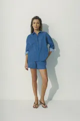 Camisa marrón a rayas verticales negras y rojas, de corte relaxed, con cuello clásico y botones al tono.