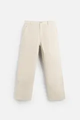 Pantalón de pana color crema, corte relaxed fit, con bolsillos frontales, bolsillos de parche en la parte trasera, bolsillos laterales en las piernas, trabilla multifunción y cierre con cremallera y botón.