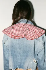 Cuello desmontable con estampado de cuadros vichy rojos y blancos, detalle de flores bordadas y volados en el borde. Se ata al frente con lazos del mismo tejido.