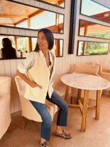 Chaleco plateado reversible con interior de gamulan color crema, con bolsillos delanteros.