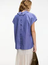 Camisa musculosa a rayas verticales azules y blancas, con cuello camisero, botones en la parte delantera y trasera, y lazo regulable en el cuello.