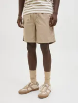 Short chino color beige de fit relajado con tiro semi caído. Cintura con cierre de cremallera y cordón ajustable. Bolsillos delanteros y traseros. Confeccionado en tejido canvas de algodón y lino.