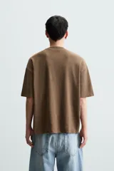 Camiseta azul marino de corte holgado, confeccionada en algodón con cuello redondo y mangas cortas. Presenta un efecto de lavado que le da una apariencia única.