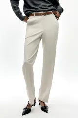 Pantalón negro de tiro alto con pernera recta, bolsillos frontales y falsos bolsillos con solapa en la espalda. Incluye cinturón marrón de cuero sintético.