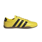Championes Adidas Grand Court Lo amarillos con las tres tiras laterales en negro y suela marrón. Confeccionados en cuero y material sintético.