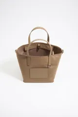 Bolso bandolera de nylon color corteza, con cierre de mosquetón y cremallera, y doble asa de mano de piel.