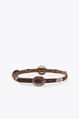 Cinturón marrón de cuero con apliques metálicos plateados y piedras rojas.
