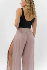 Pantalón blanco de gasa liviana con cintura elástica y aberturas laterales con detalle de pompones.