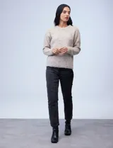 Buzo de tejido melange color beige con puntos oscuros, cuello redondo y manga larga.