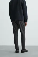 Pantalón largo de vestir gris claro con estampado de cuadros, corte slim fit y cintura elástica. Confeccionado en tejido con alta elasticidad, bolsillos frontales y cierre frontal con cremallera y botón.