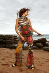 Pantalón de tiro medio con elástico en la cintura y corte acampanado. Diseño con estampado multicolor de patchwork con motivos florales y geométricos.