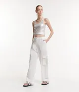 Pantalón de vestir blanco, de corte recto, con bolsillos cargo laterales y detalle de aro metálico en la trabilla.