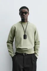 Sudadera verde militar de algodón con interior de rizo, corte relaxed fit, cuello redondo y mangas largas con puños y ruedo acanalados.