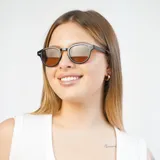 Lentes de sol redondos con montura de carey y lentes verdes.