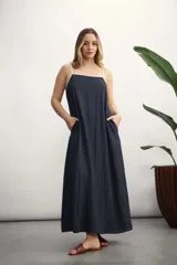 Vestido largo azul marino con breteles finos blancos, corte recto y bolsillos laterales.