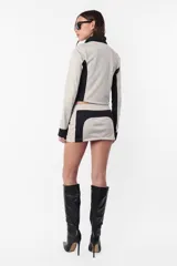 Campera deportiva negra con recortes grises en mangas y laterales. Cierre frontal y calce slim fit. Estampa de logo a tono en el recorte delantero.