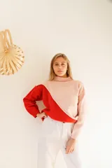 Sweater de punto color crema y mostaza, con cuello cisne y diseño asimétrico.